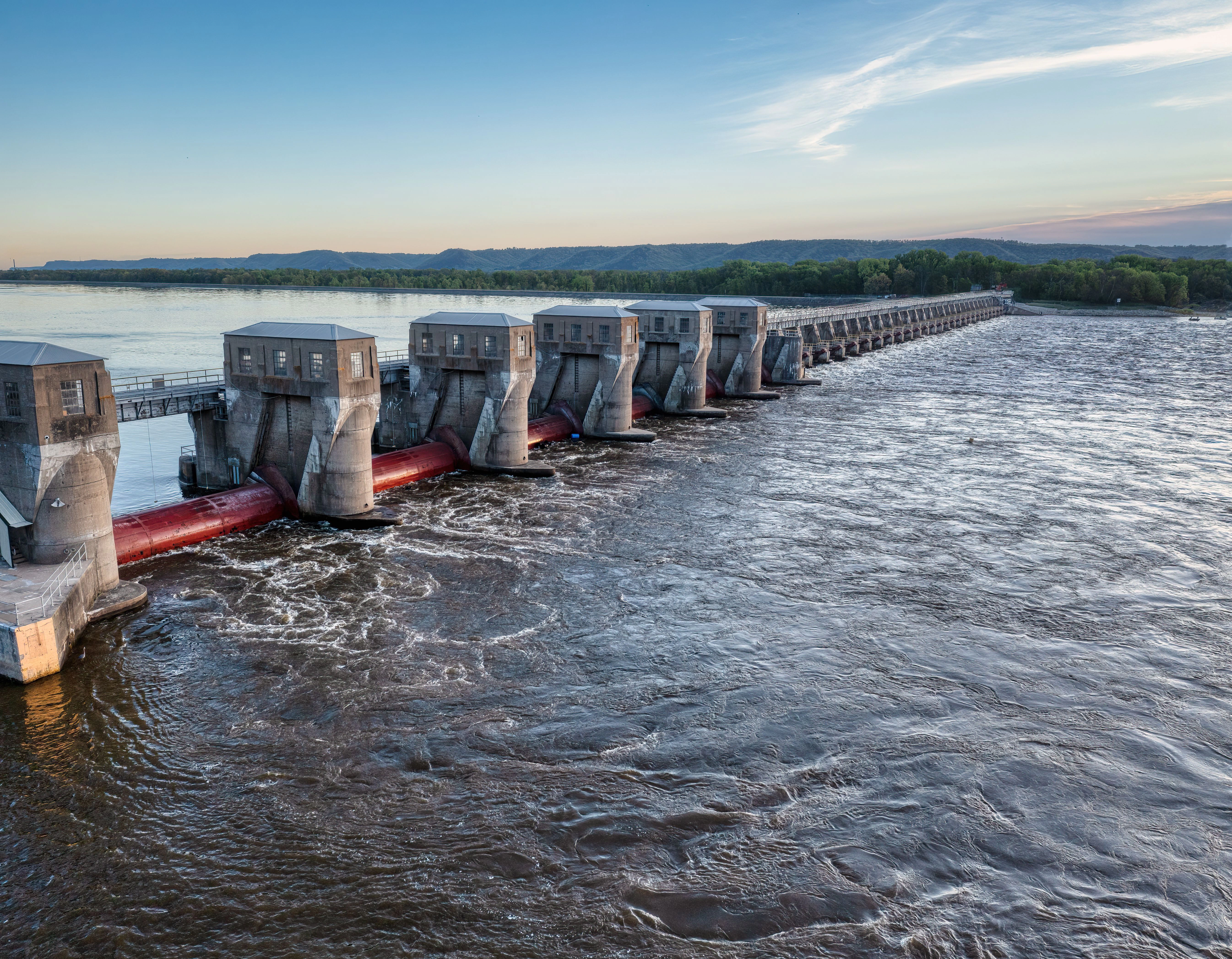 A wide dam holding back a river, water rushing through its gates — building your dam upstream, the recovery strategy of stopping sexual addiction and compulsive behavior before the flood starts